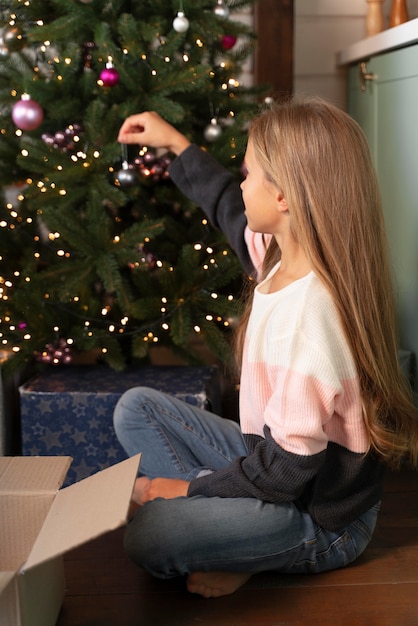 Niña decorando el árbol de navidad