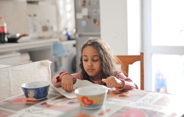 la niña desayuna en la mesa de la cocina