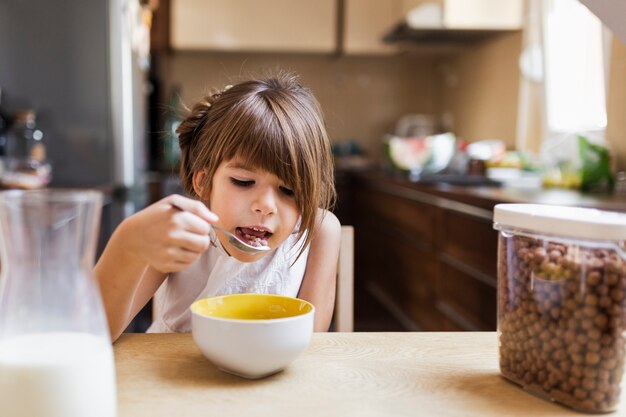 Niña desayunando por la mañana