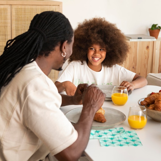 Foto gratuita niña desayunando con su padre