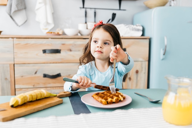 Niña desayunando