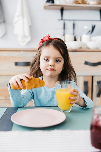 Foto gratuita niña desayunando