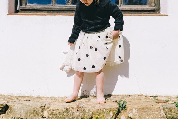 Niña descalza con ovejas de juguete