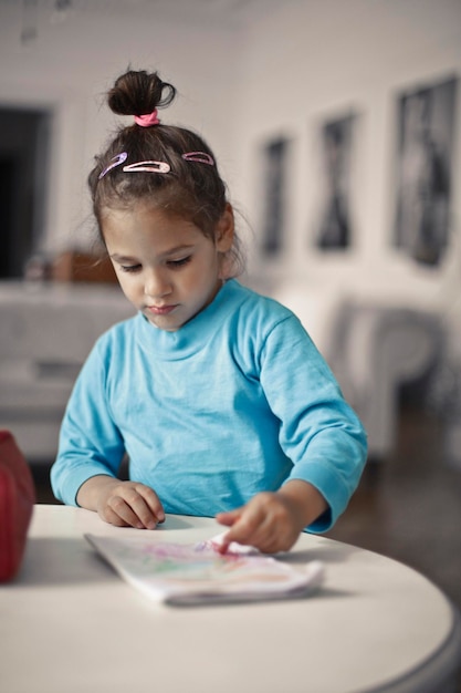 Niña dibuja en papel en casa