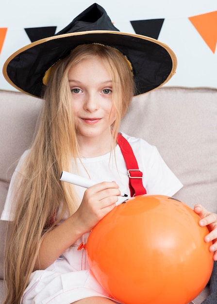 Foto gratuita niña dibujando un globo de halloween