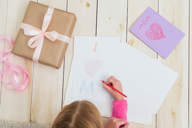 Foto gratuita niña dibujo amo a mamá sobre papel