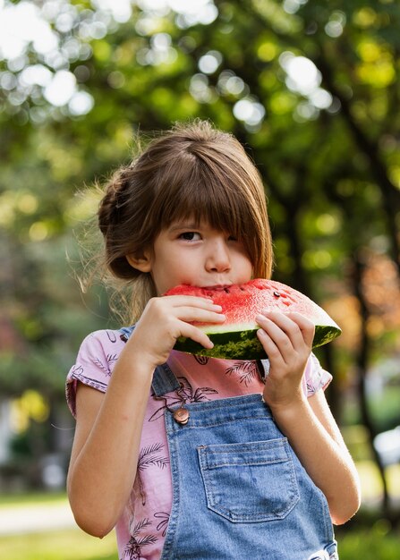 Niña disfrutando de sandía al aire libre