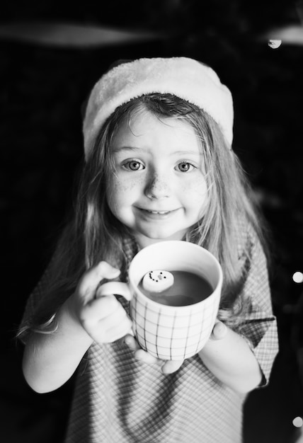 Foto gratuita niña disfrutando de una taza de chocolate caliente