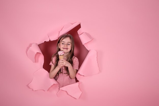 Niña divertida con helado sobre fondo de color