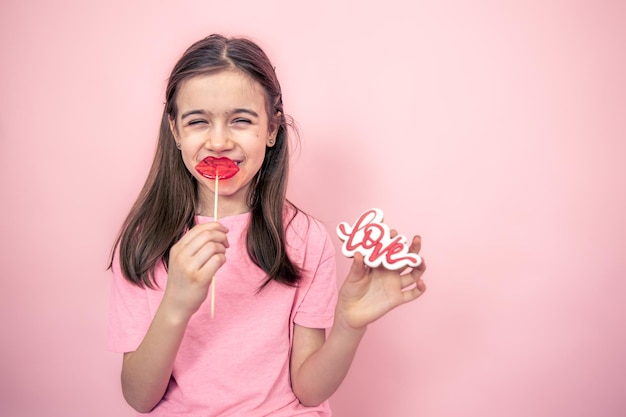 Niña divertida con una piruleta en forma de labios en sus manos copia espacio