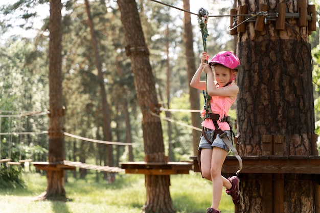 Niña divirtiéndose en un parque de aventuras