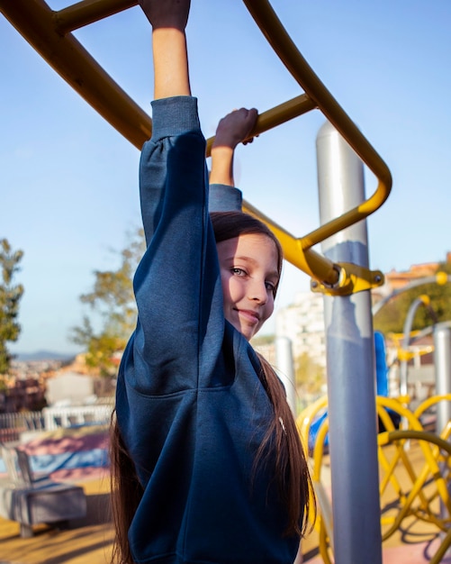 Niña divirtiéndose en el patio de recreo afuera