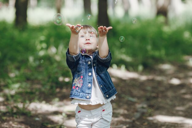 Niña divirtiéndose con las pompas de jabón en el parque