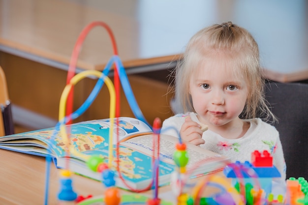 Niña en edad preescolar con libro