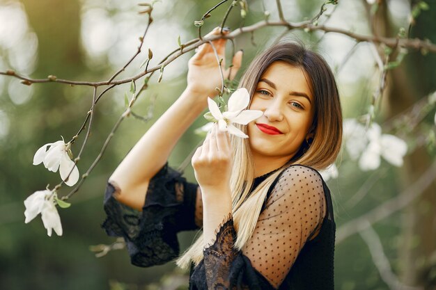 Niña elegante en un parque de primavera