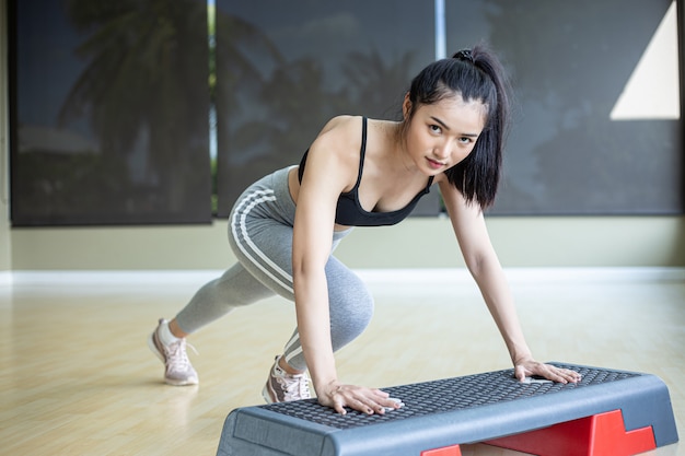 La niña empujó hacia arriba con los escalones de la plataforma en el gimnasio.