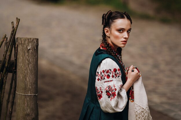 Una niña encantadora en el vestido tradicional ucraniano está caminando