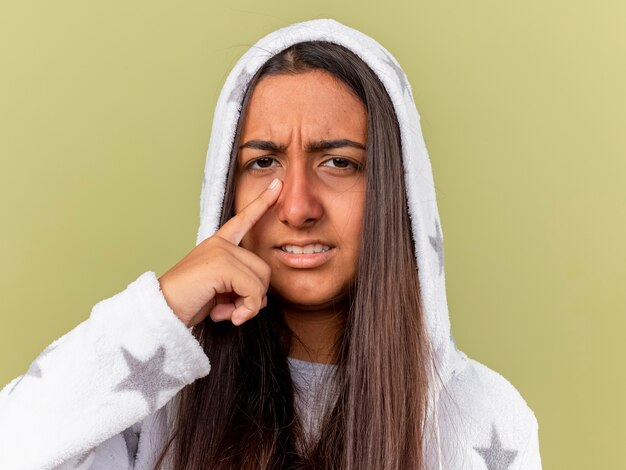 Foto gratuita niña enferma joven insatisfecha poniéndose la capucha poniendo el dedo en el ojo aislado en verde oliva