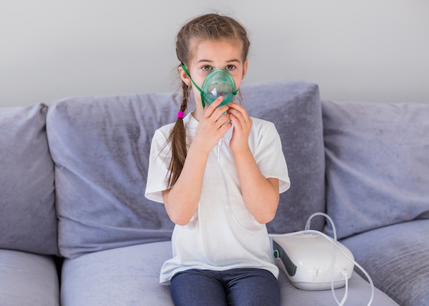 Foto gratuita niña enferma con mascarilla