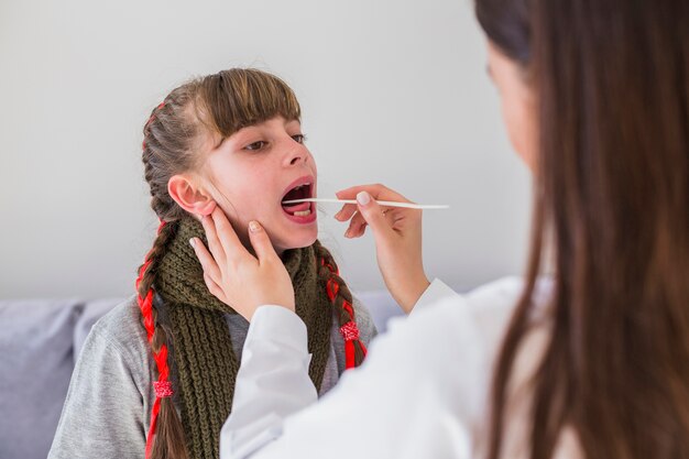 Niña enferma siendo examinada por la doctora