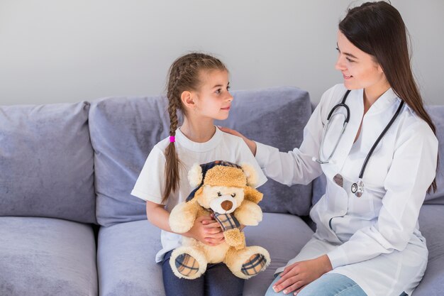 Niña enferma siendo examinada por la doctora