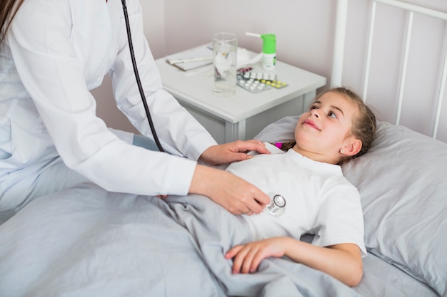 Niña enferma siendo examinada por la doctora