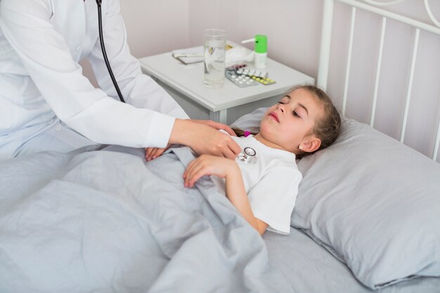 Niña enferma siendo examinada por la doctora