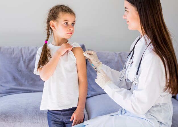 Niña enferma siendo examinada por la doctora