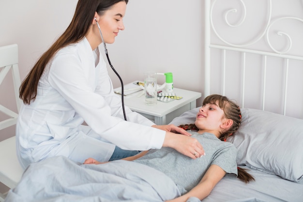 Niña enferma siendo examinada por la doctora