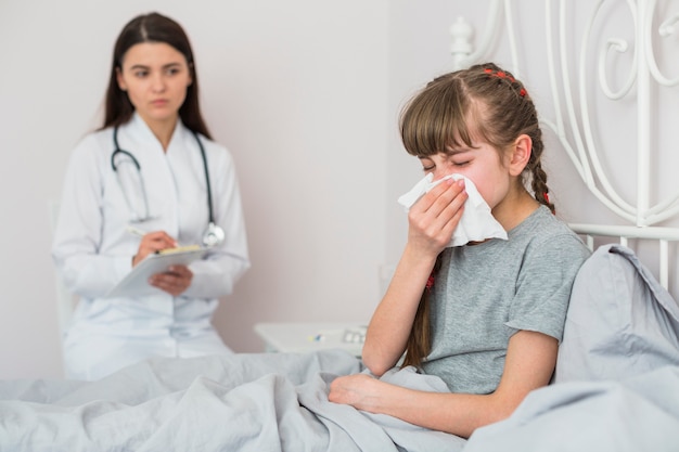 Niña enferma siendo examinada por la doctora