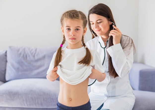 Niña enferma siendo examinada por la doctora