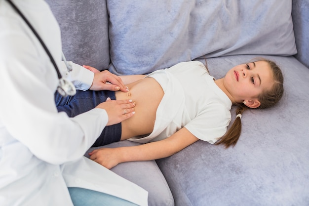 Niña enferma siendo examinada por la doctora