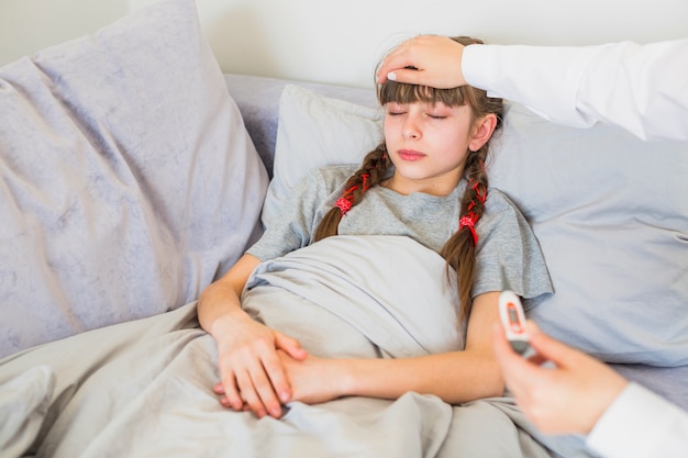 Niña enferma siendo examinada por la doctora