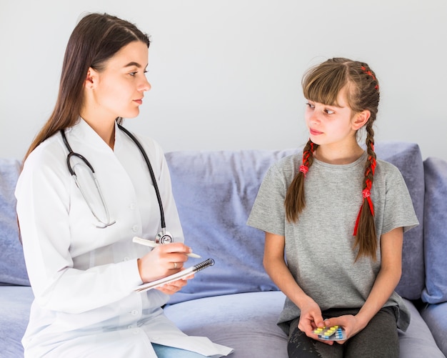 Niña enferma siendo examinada por la doctora