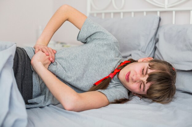 Niña enferma sintiendo dolor