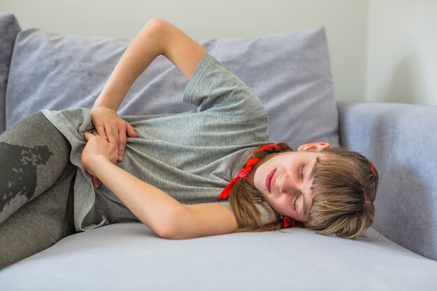 Niña enferma sintiendo dolor