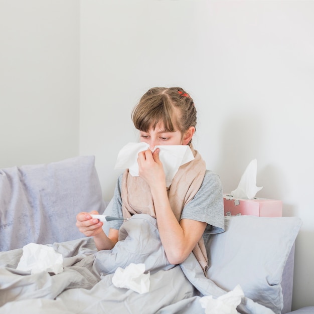 Niña enferma sonándose la nariz