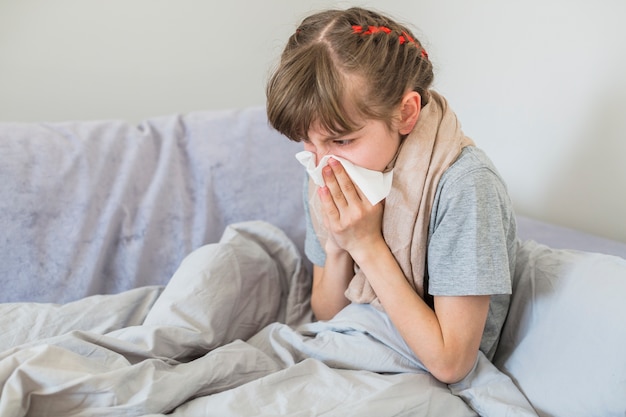 Niña enferma sonándose la nariz