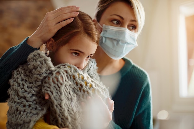 Foto gratuita niña enferma y su madre en casa durante la pandemia del coronavirus