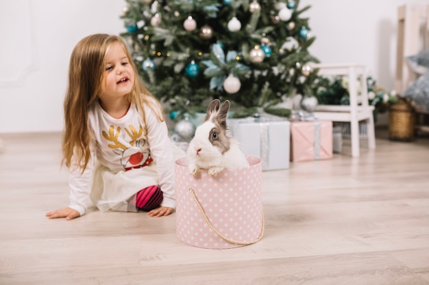 Niña enfrente de árbol de navidad en casa