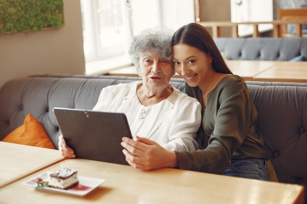 Niña enseñando a su abuela a usar una tableta