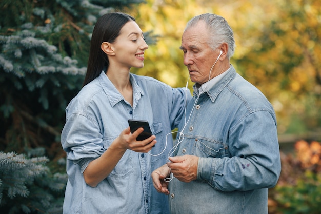 Niña enseñando a su abuelo a usar un teléfono