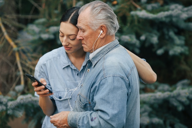 Niña enseñando a su abuelo a usar un teléfono