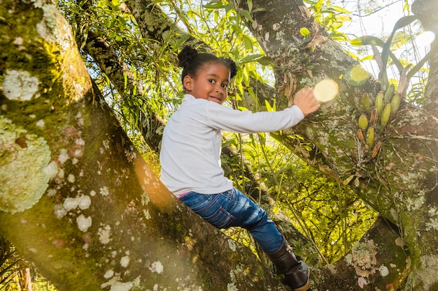 Foto gratuita niña escalando en un árbol