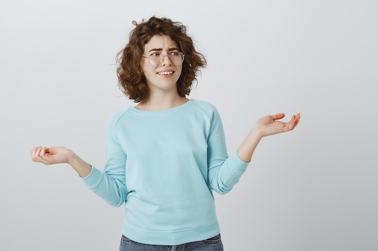 Foto gratuito niña escéptica despreocupada sonriendo y levantando las manos hacia los lados descuidada