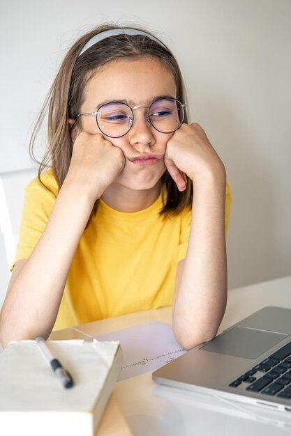 Foto gratuita niña escolar exhausta que sufre de hacer la tarea cansada de estudiar