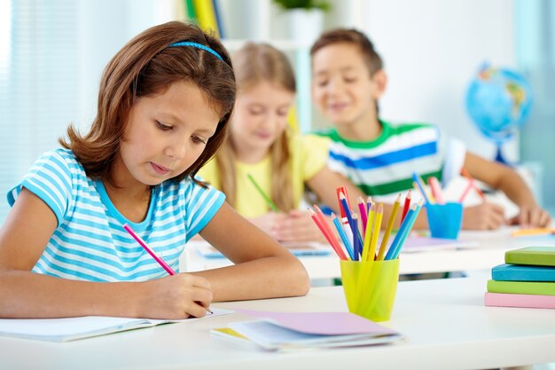 Niña escribiendo algo en su cuaderno