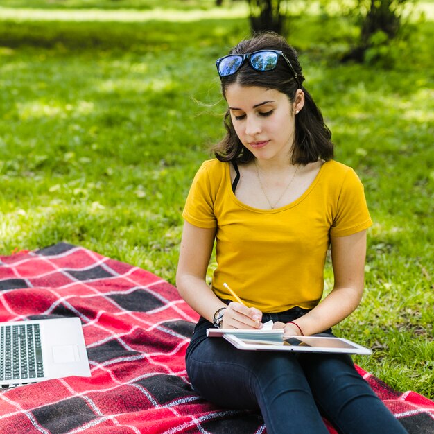 Niña escribiendo en la naturaleza