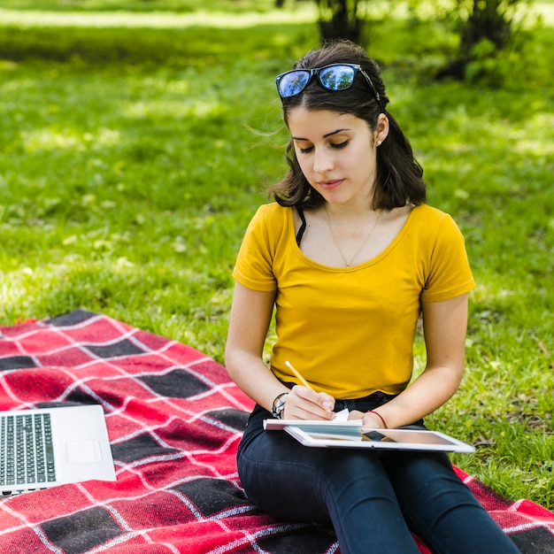 Niña escribiendo en la naturaleza