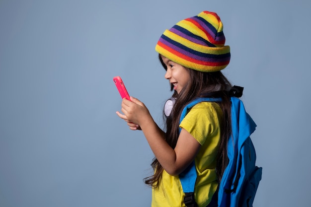 Niña de la escuela asiática comprobando su teléfono